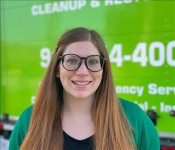Woman standing in front of green SERVPRO background. 